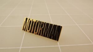 "Motorman" Script Lapel Pin – Gold-tone